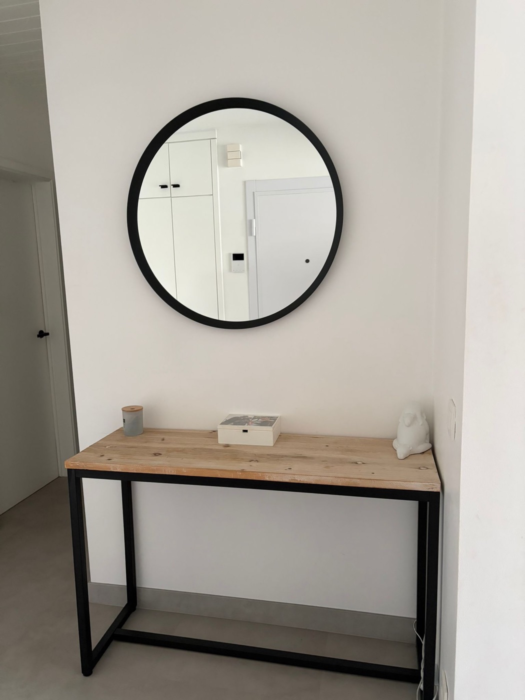De gang voor de plaatsing: een losse sidetable met een ronde spiegel